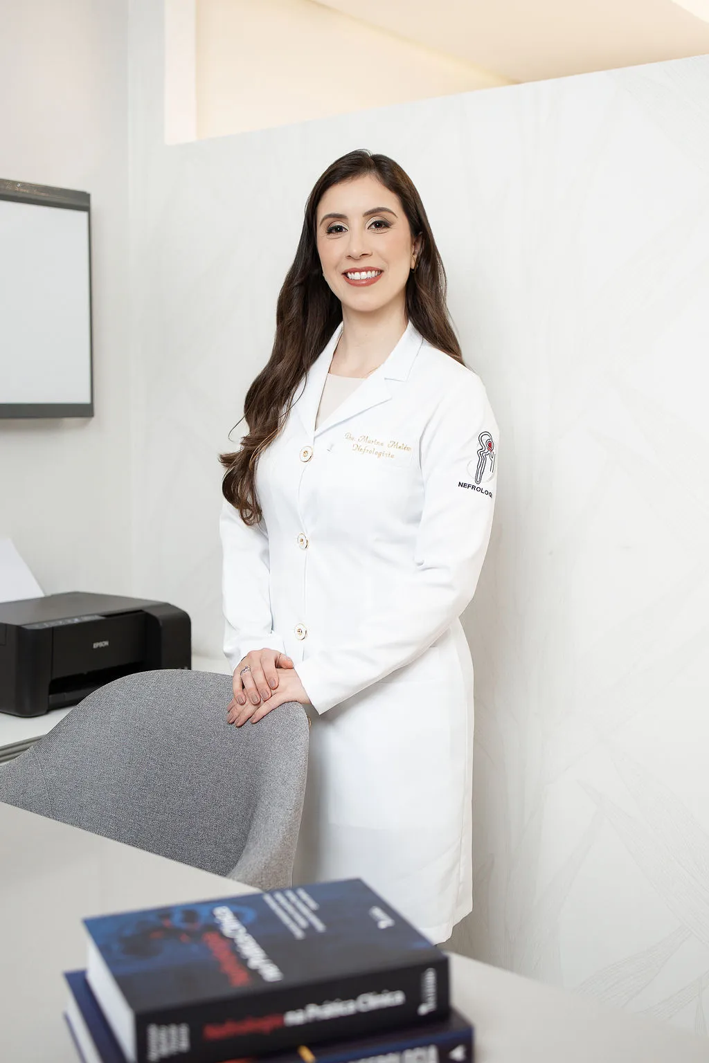 Dra. Marina Melém de jaleco no consultório